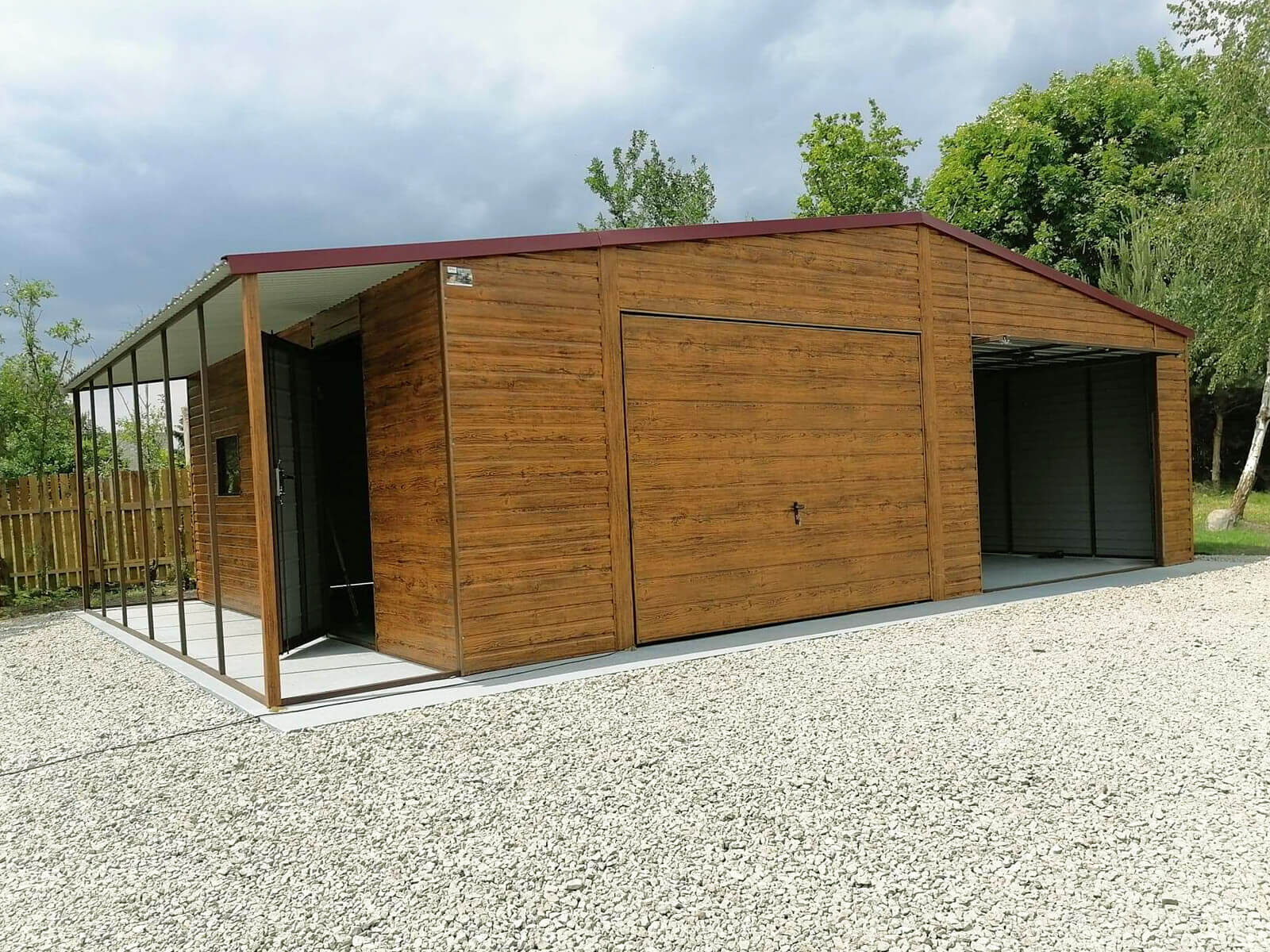 Garaż blaszany złoty dąb 8 x 6 + wiatka 1 x 6 dach dwuspadowy widok z przodu, jedna brama zamknięta, druga podniesiona, drzwi boczne uchylone