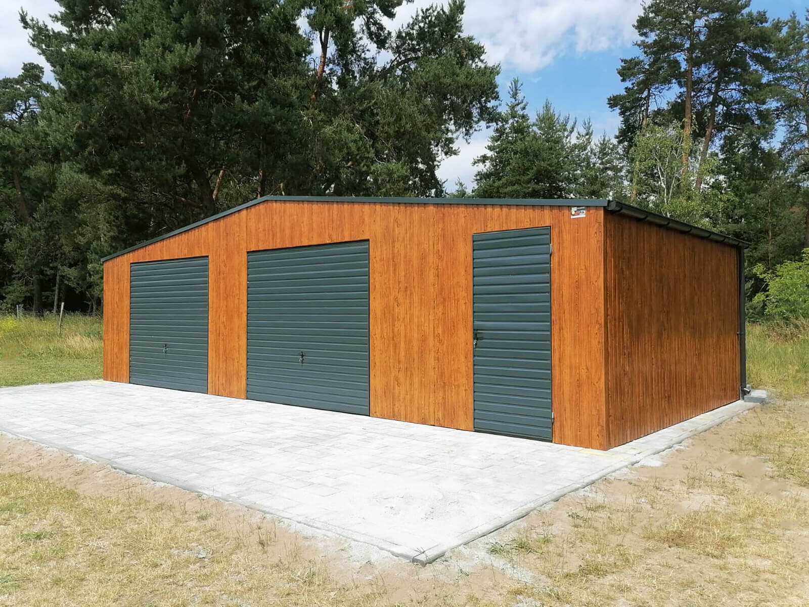 Garaże blaszane na zdjęciu garaż blaszany drewnopodobny złoty dąb z bramami i drzwiami koloru grafit mat 7016