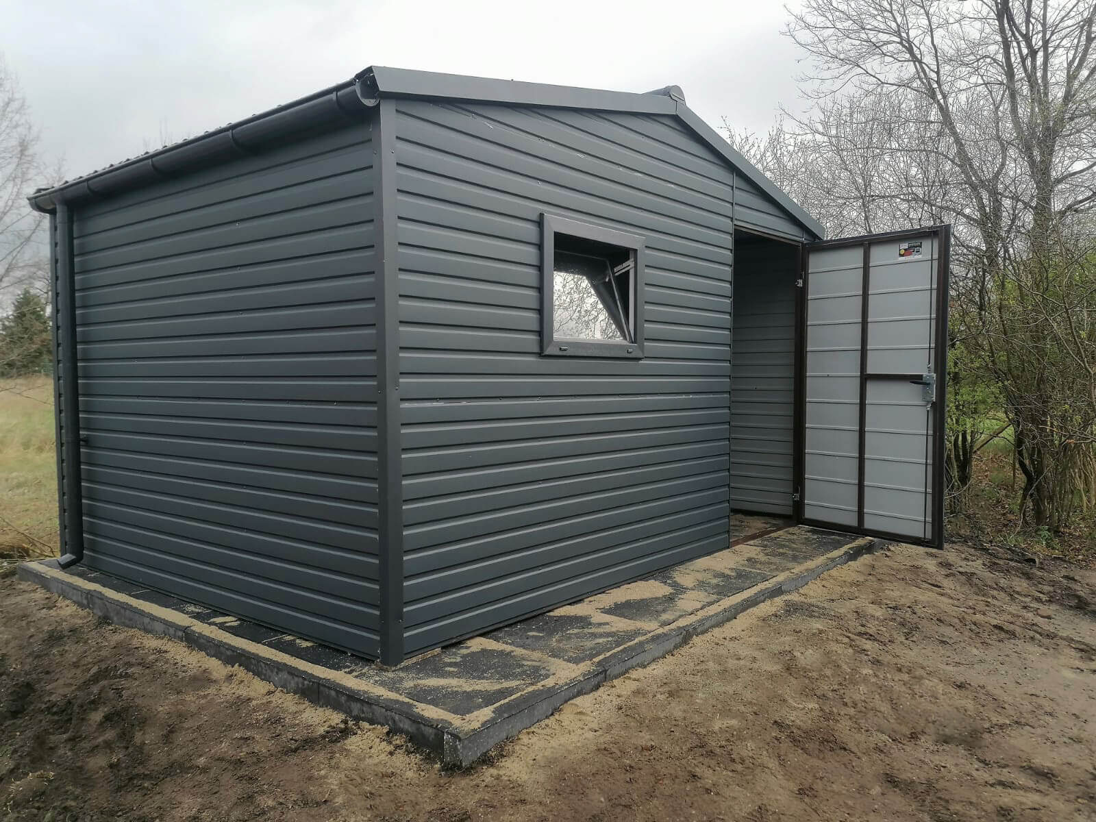 Domek ogrodowy 4 x 2 dwuspadowy BTX 7016 Grafit mat widok z przodu z otwartymi drzwiami, okno na frontowej ścianie uchylone