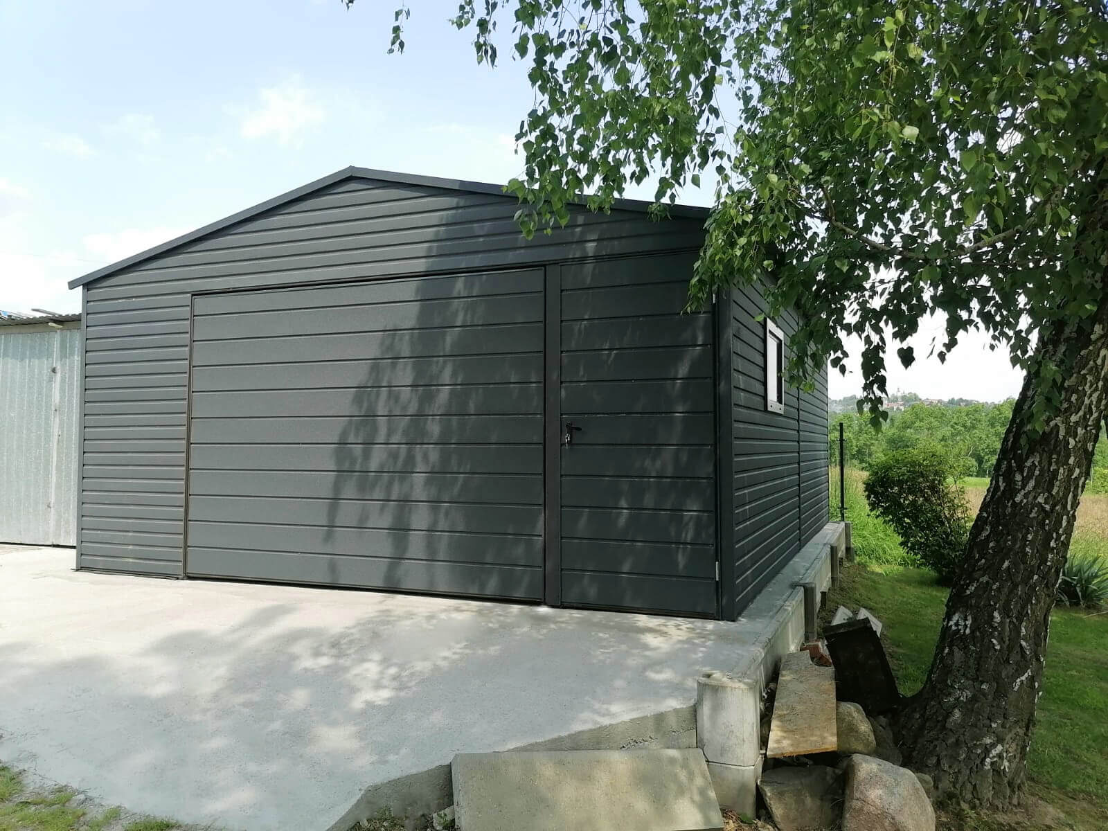 Garaż blaszany 5 x 6 Grafit Mat jednostanowiskowy, dwuspadowy widok z przodu, brama uchylna zamknięta, drzwi frontowe zamknięte