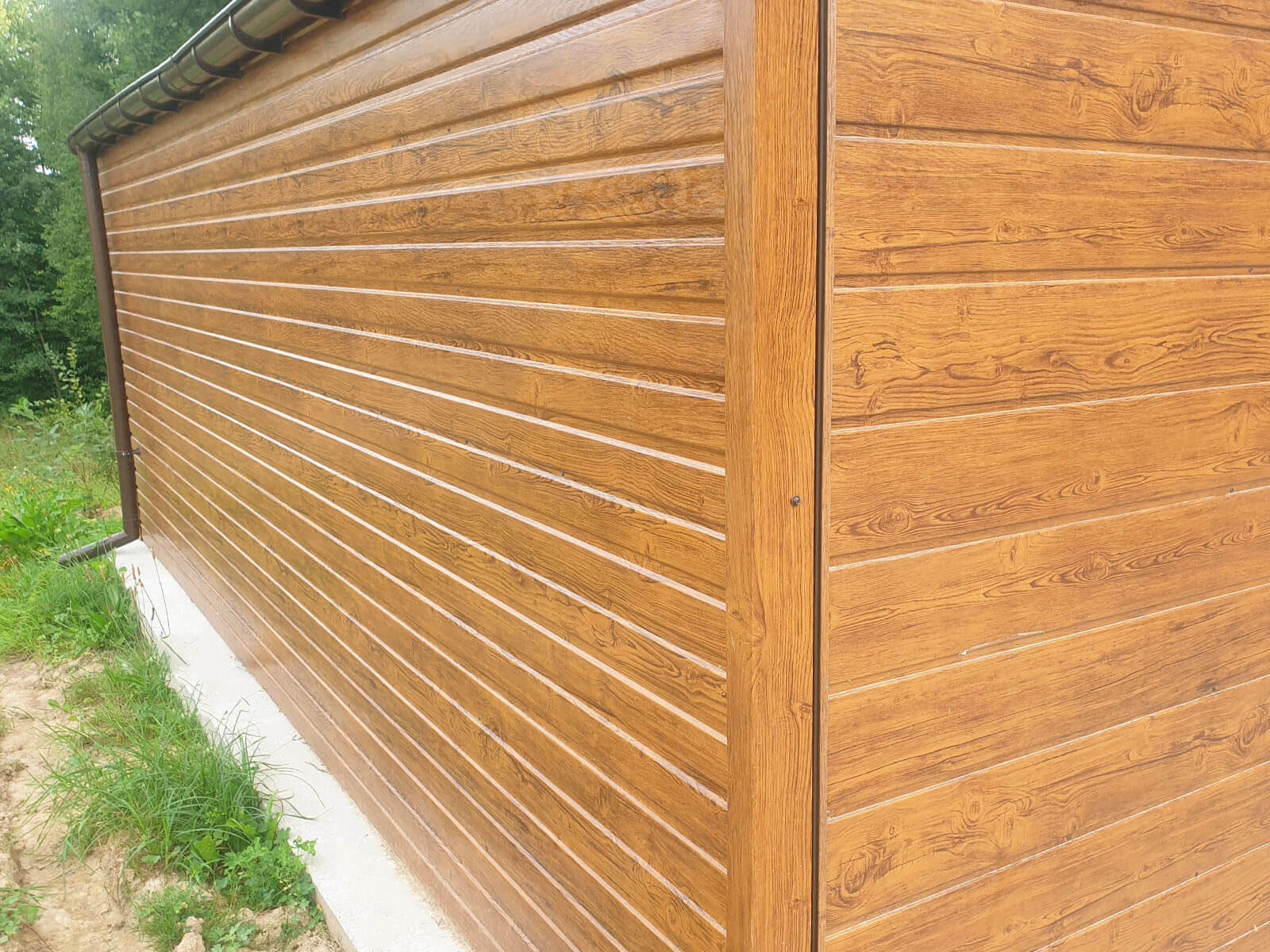 Garaż blaszany 6 x 6,50 drewnopodobny złoty dąb, dwie bramy zbliżenie na okucie boczne