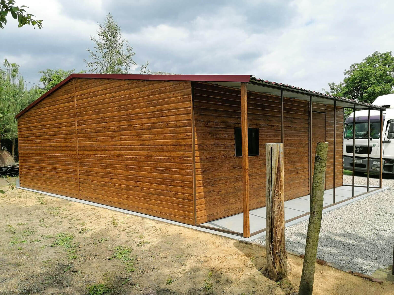 Garaż blaszany złoty dąb 8 x 6 + wiatka 1 x 6 dach dwuspadowy widok z tyłu, widoczna wiata, drzwi oraz okno